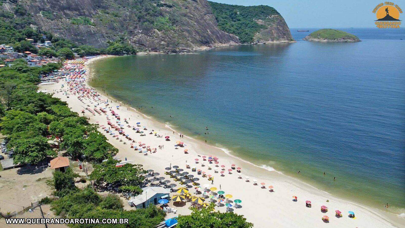 Vista aérea da Praia de Itaipu em Niterói com mar cristalino e montanhas