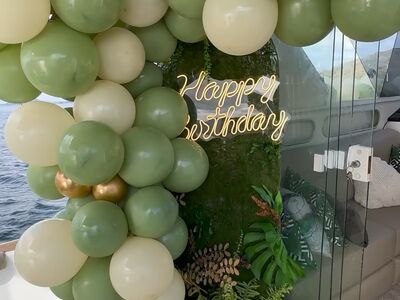 Decoração de aniversário na lancha com balões verdes e letreiro Happy Birthday